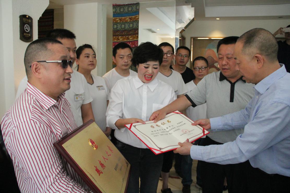 经大忠向绵阳市何氏推拿中心颁发“全国残疾人之家”奖牌