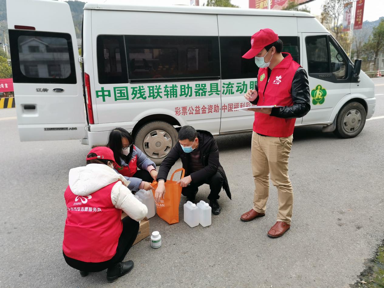 助残志愿者将新冠病毒感染肺炎疫情防护物资交给通江县残联工作人员