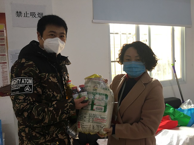 双桥子街道五冶社区工作人员将爱心企业捐赠的生活物资送到困难残疾人家中