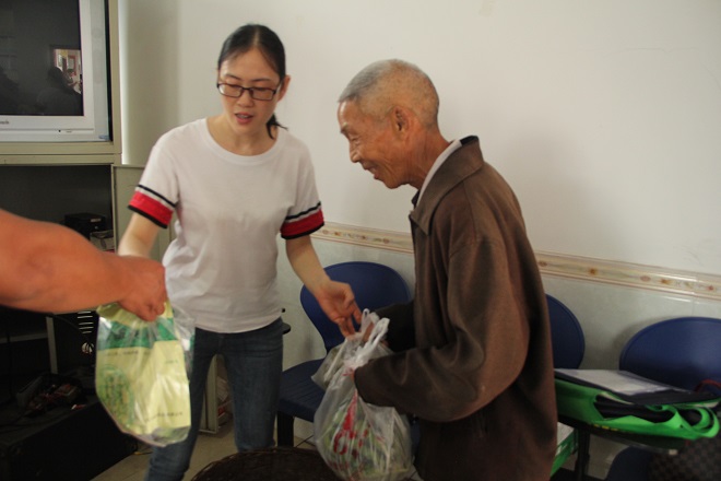 图片：县残联副理事长曾有会为贫困户送节日慰问品