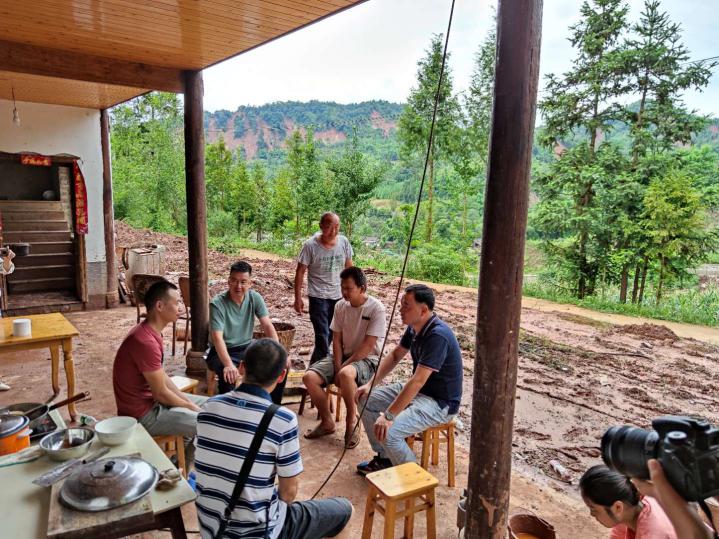 图片：周万平一行在芦山县龙门镇看望受灾残疾贫困人