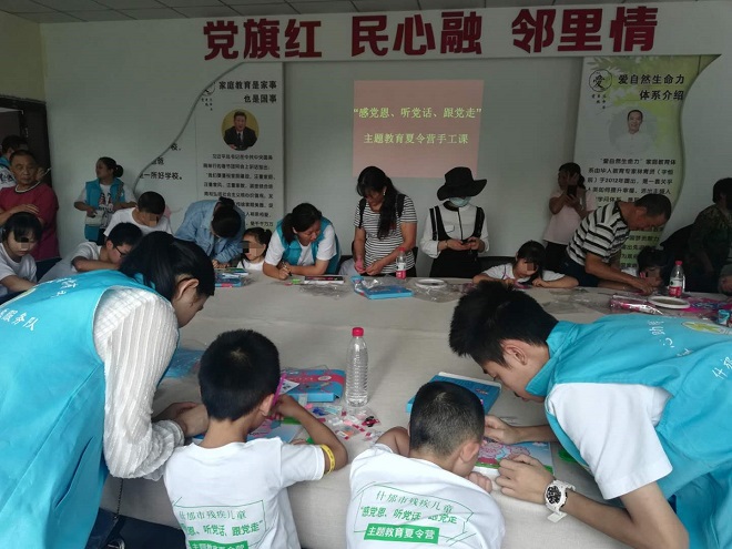 图片：孩子们在志愿者的帮助下制作精美的手工作品