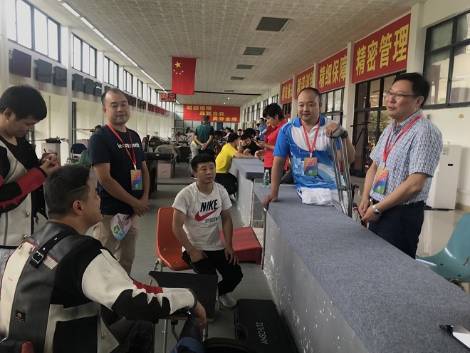 图片：成华区残联党组书记、理事长韦华听取教练员情况介绍