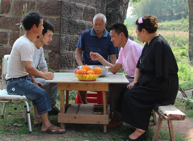 图片：王忠全给上门求教的残疾人讲解龙虾养殖技术
