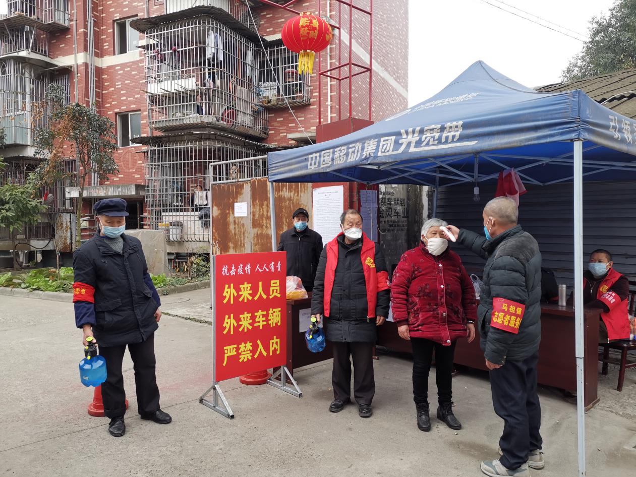 3名残疾人志愿者老人正在为进出的居民量体温、消毒